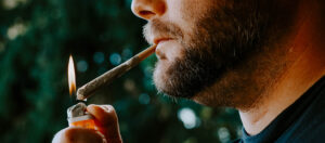 man smoking a marijuana cigarette graphic for article about weed prohibition